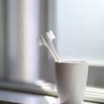 two white toothbrush inside the white ceramic cup